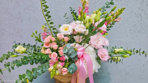 Basket with flowers, wine and treats