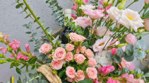 Basket with flowers, wine and treats